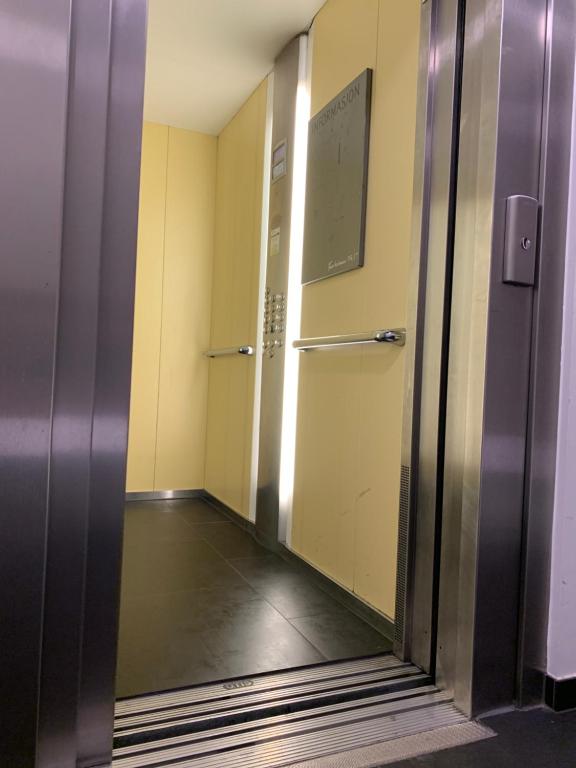 an elevator in an office building with a glass door at Budget Small Room City Centre in Oslo