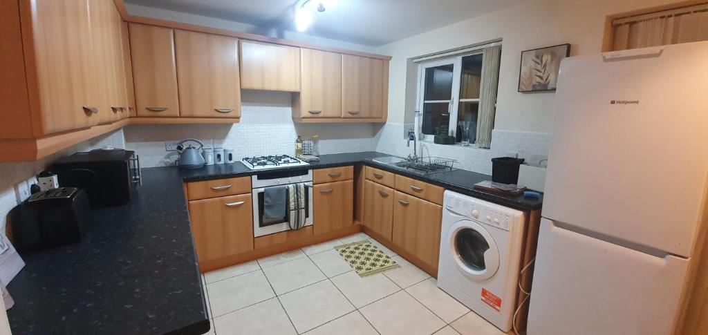 a kitchen with a refrigerator and a washing machine at Larkspur House in West midlands in Bedworth