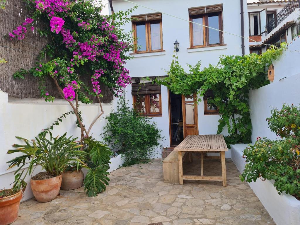 einen Innenhof eines Hauses mit einem Tisch und Blumen in der Unterkunft Preciosa casa de pueblo con vistas y patio in Jimena de la Frontera