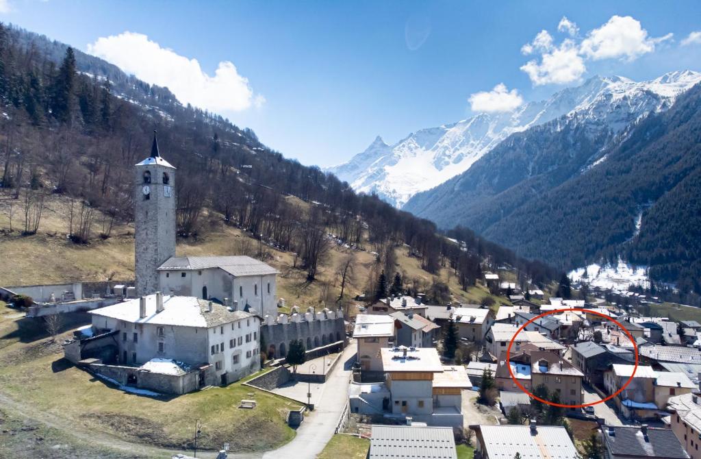 a small town with a clock tower in the mountains at Chalet Hotel La Tarine in Peisey-Nancroix