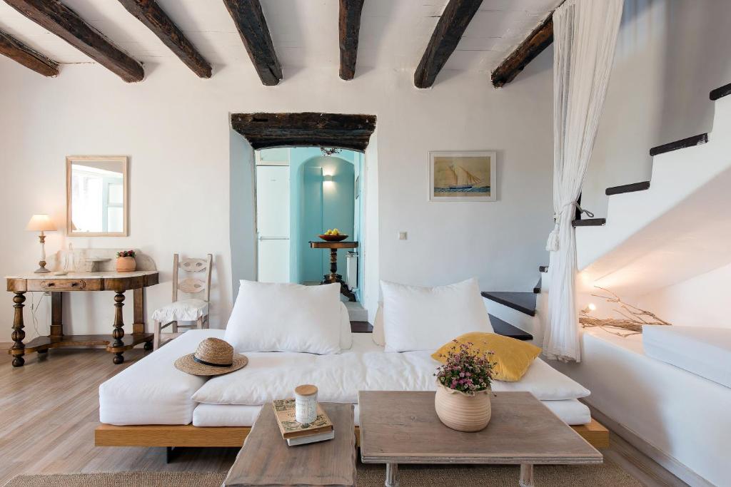 a living room with a white couch and a table at Korakiana Cottage in Áno Korakiána