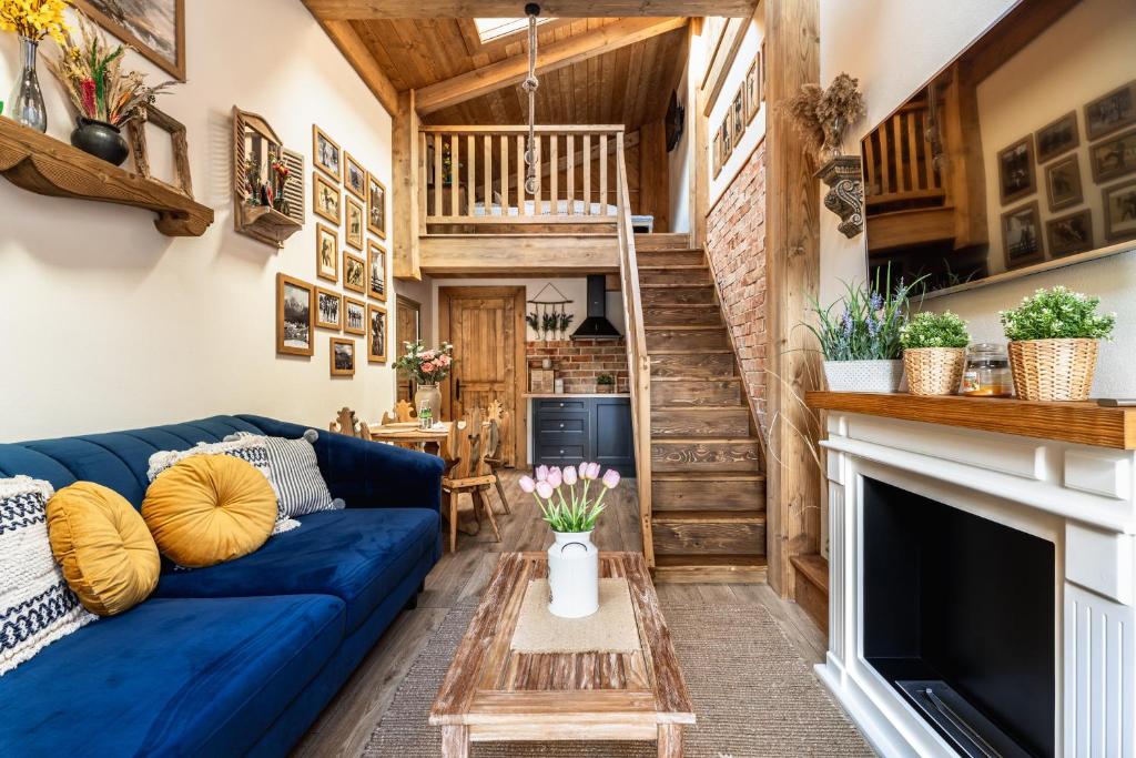 a living room with a blue couch and a fireplace at Górska Antresola in Zakopane