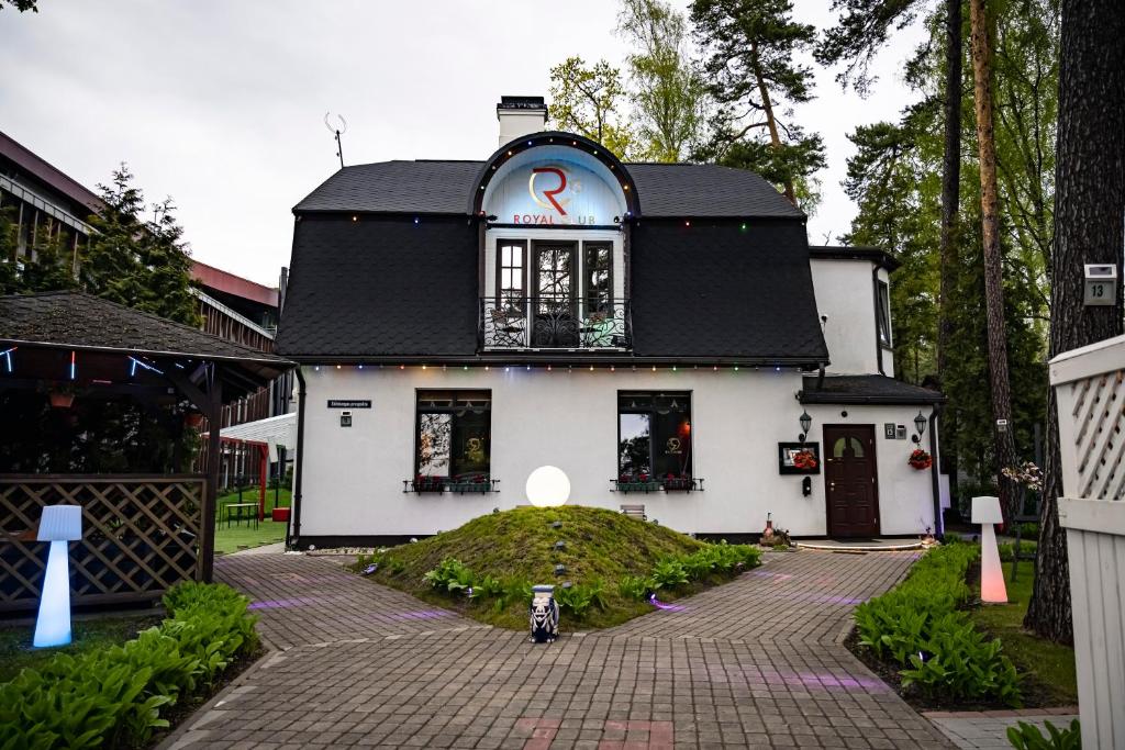 ein kleines weißes Haus mit schwarzem Dach in der Unterkunft Villa ROYAL CLUB 13 in Jūrmala