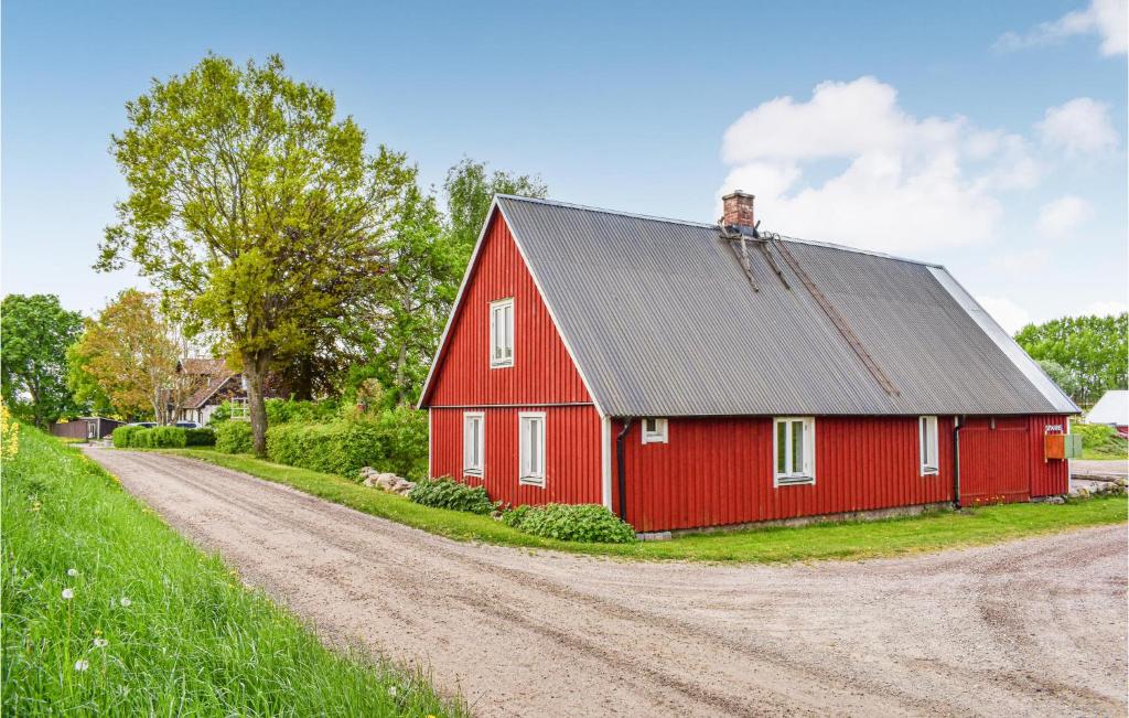 un granero rojo con techo negro en un camino de tierra en Stunning Home In Eslv With House A Panoramic View, en Eslöv