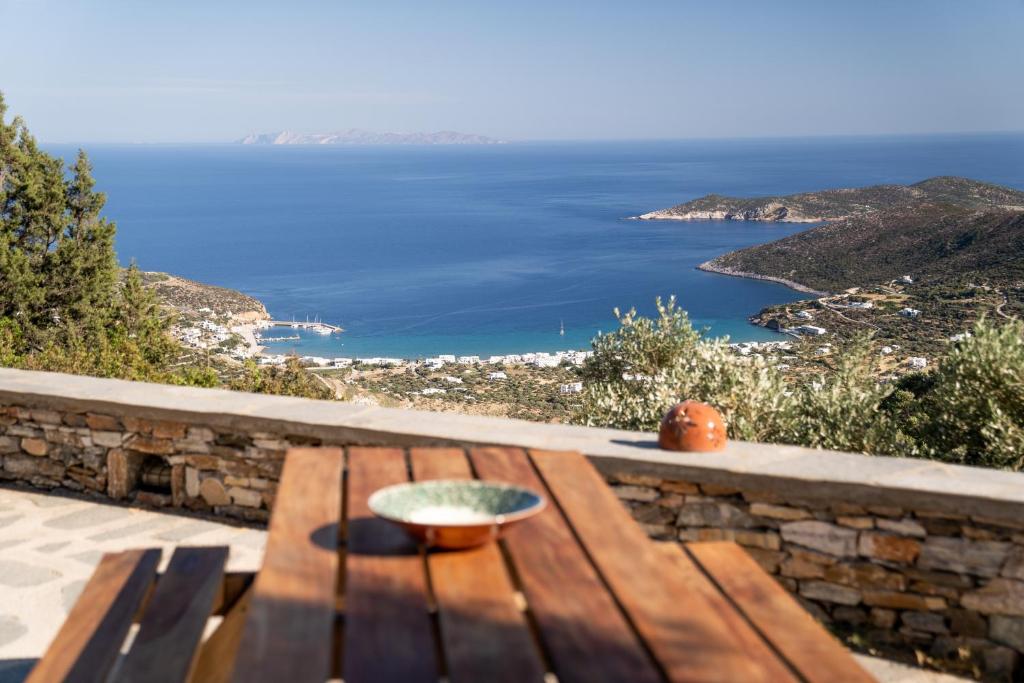 un banc en bois assis sur un mur en pierre avec vue sur l'océan dans l'établissement Flaros House-Traditional Cycladic House, Sifnos, à Platis Gialos