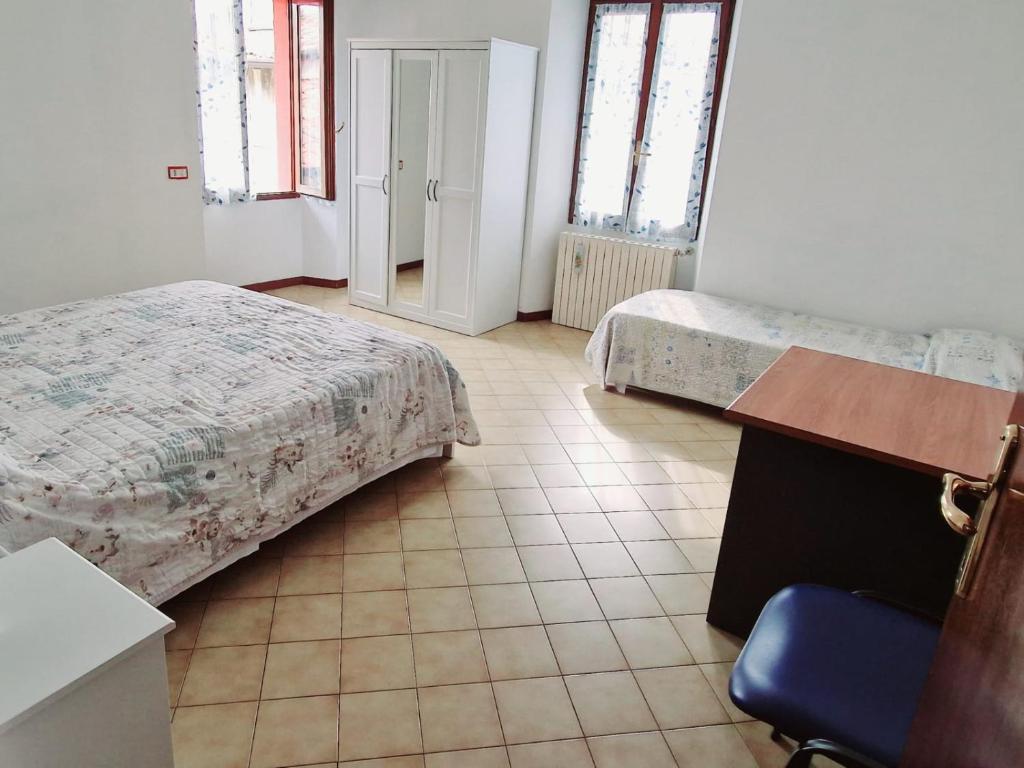 1 dormitorio con 2 camas, mesa y silla en BORGO VOLCIANO GARDA LAKE APP.2 en Roe