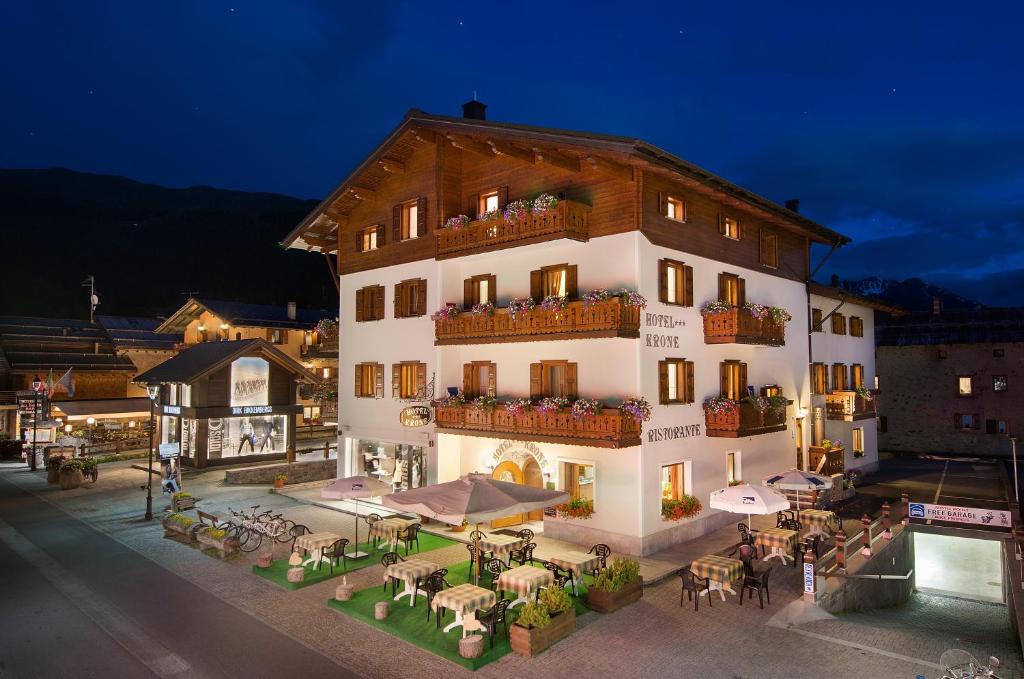 a large building with tables and chairs in front of it at Hotel Krone in Livigno