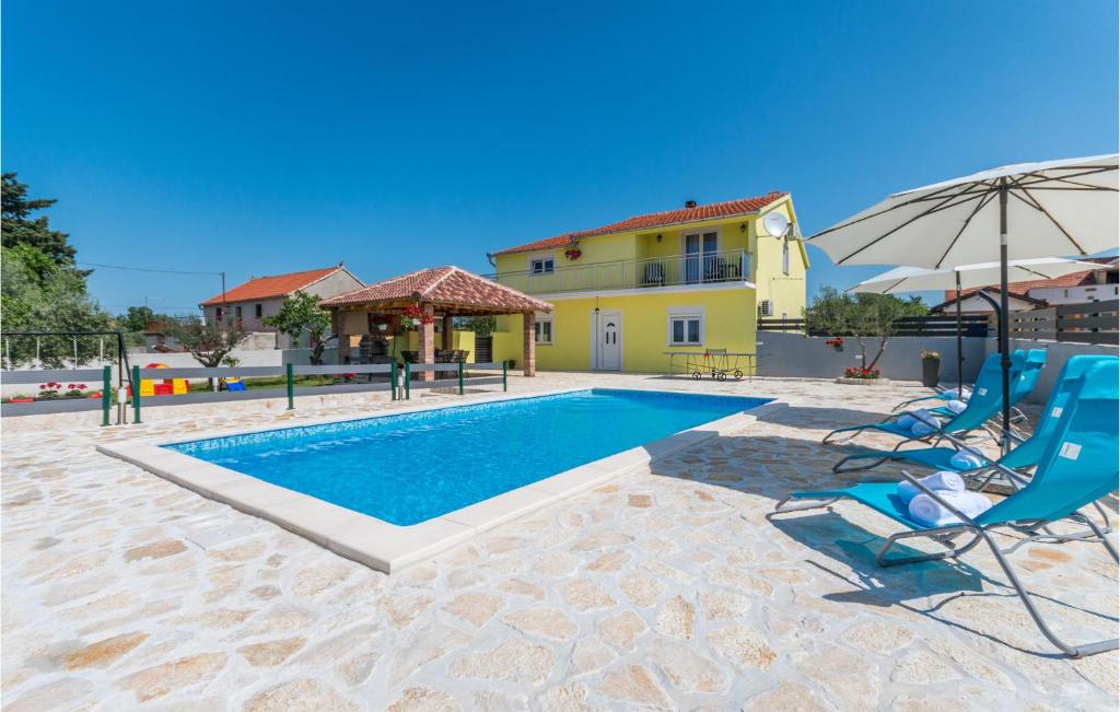 uma piscina com cadeiras e um guarda-sol e uma casa em Nice Apartment In Gornje Rastane With Wifi em Donje Raštane