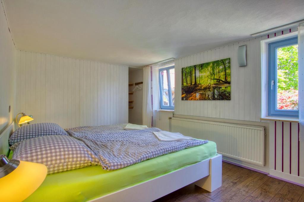 1 dormitorio con 1 cama y una pintura en la pared en Tom olen Stien - Heidjer Ferien, en Oldendorf