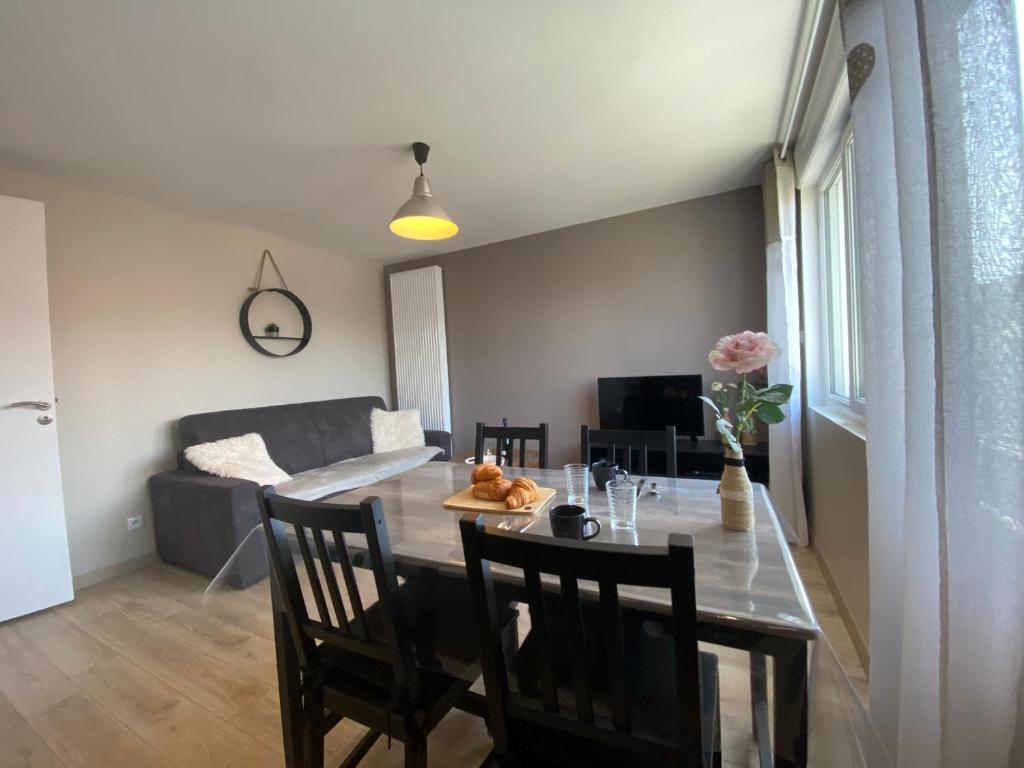 a dining room and living room with a table and chairs at Champêtre - Gîte entièrement neuf à 100 mètres de la plage in Wimereux