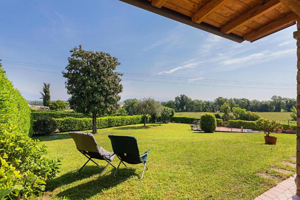 duas cadeiras sentadas na relva num quintal em Casa Alba con giardino e patio by Wonderful Italy em Lonato