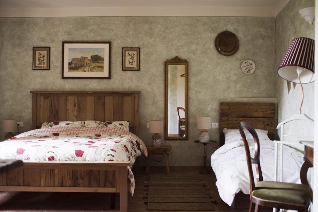 a bedroom with a bed and a mirror at La Bugia del Sensale in San Donato in Poggio