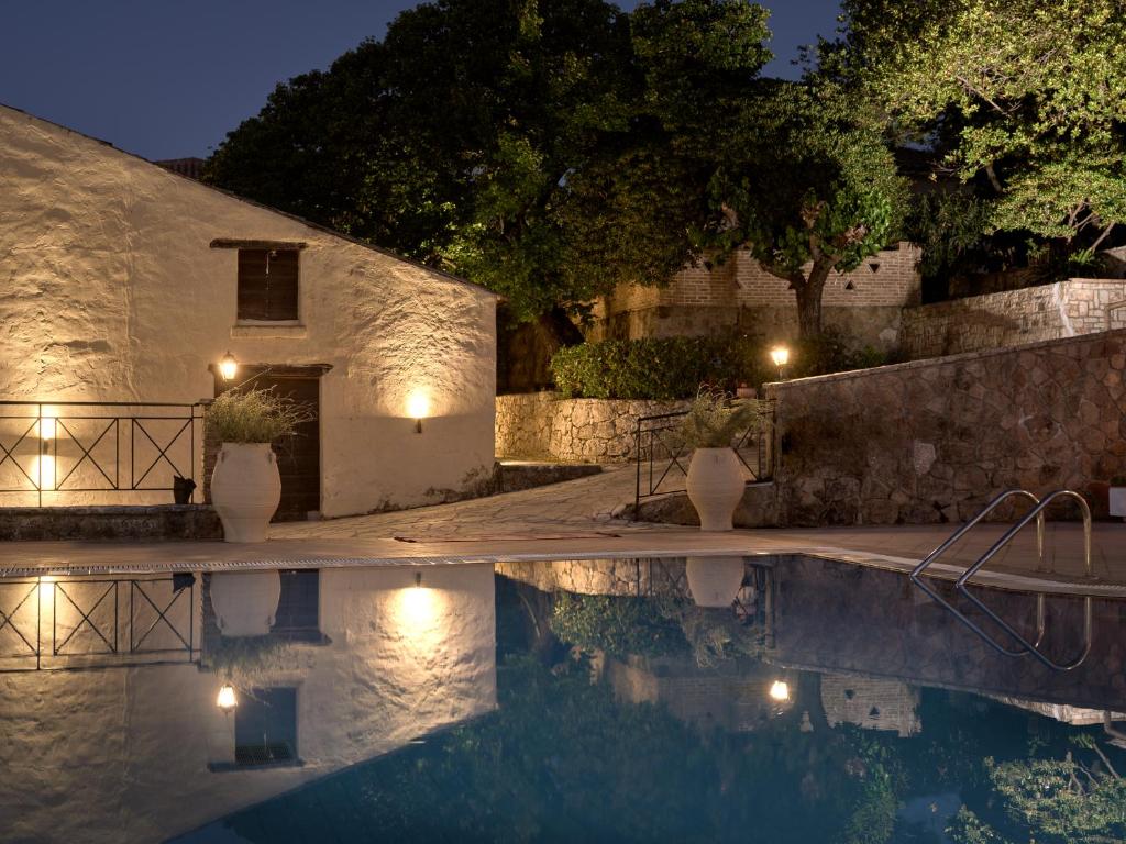 uma villa com piscina à noite em Razis Apartments em Tsilivi