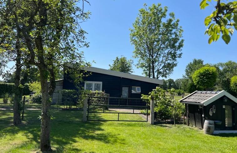 una casa negra con una valla y un patio en 4seasonshouse en Losser