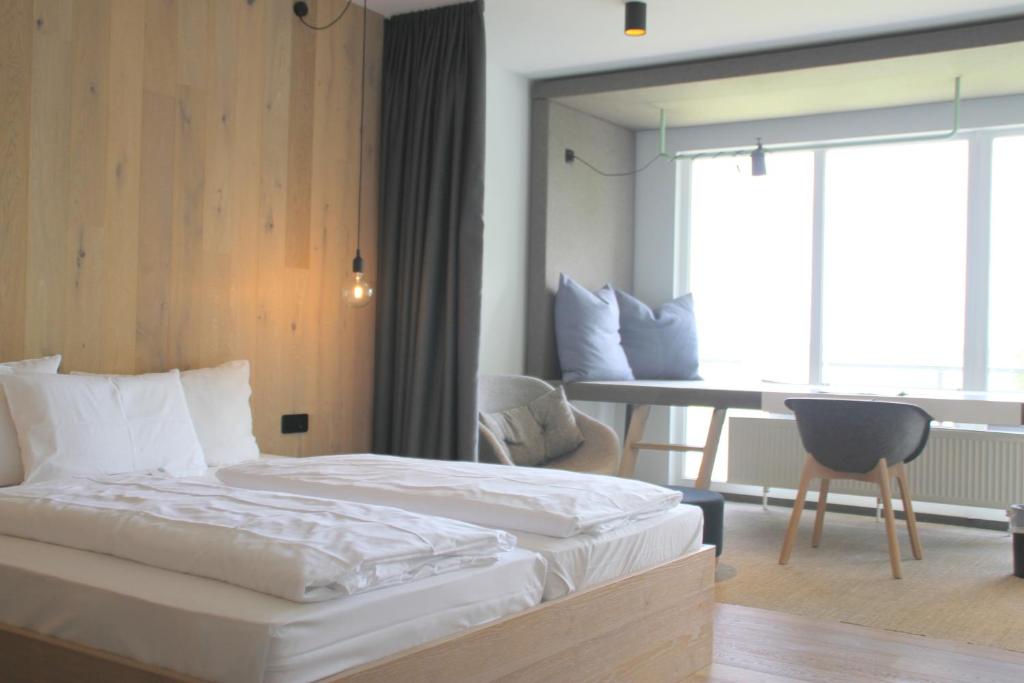 a bedroom with a bed and a table and a desk at Junior-Suite am Plönersee in Ascheberg