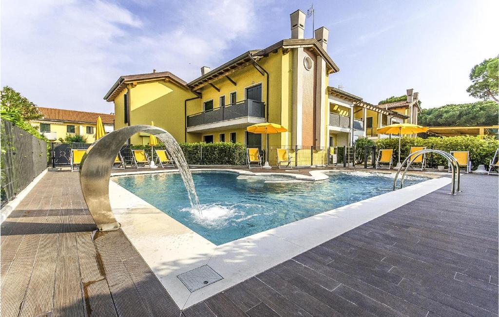 Stunning Apartment In Cavallino-treporti With Outdoor Swimming Pool في كافالّينو تريبورتي: مسبح امام مبنى نافورة ماء