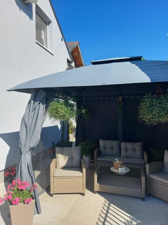 a patio umbrella with chairs and a table at Harmonija Lux in Vrdnik