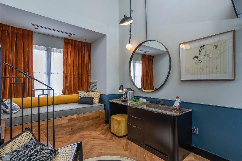 a living room with a bed and a mirror at Backstage Hotel - an Atlas Boutique Hotel in Tel Aviv