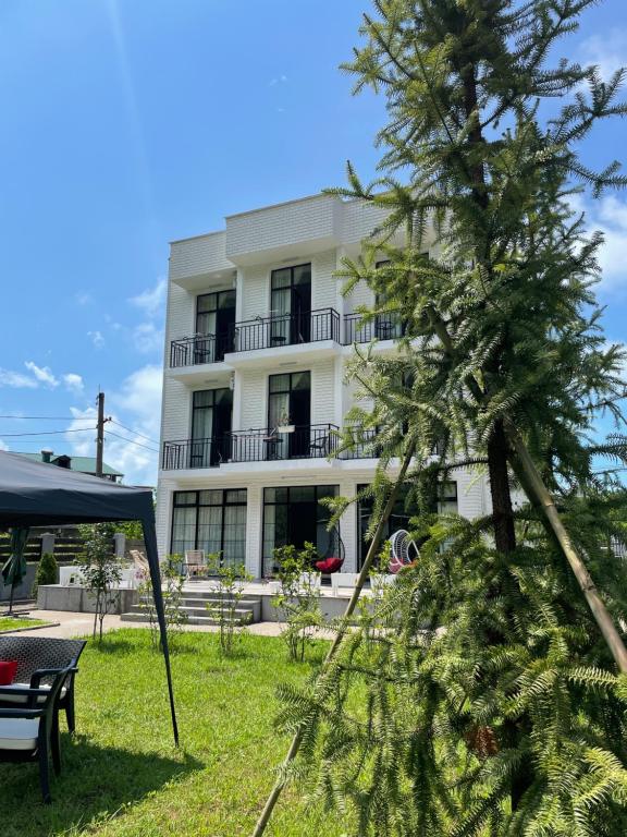 a large white building with a tree in front of it at Villa Flora in Gonio