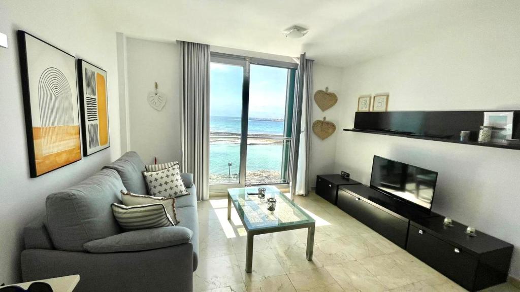 a living room with a view of the ocean at Pearl Apartment Corralejo in Corralejo