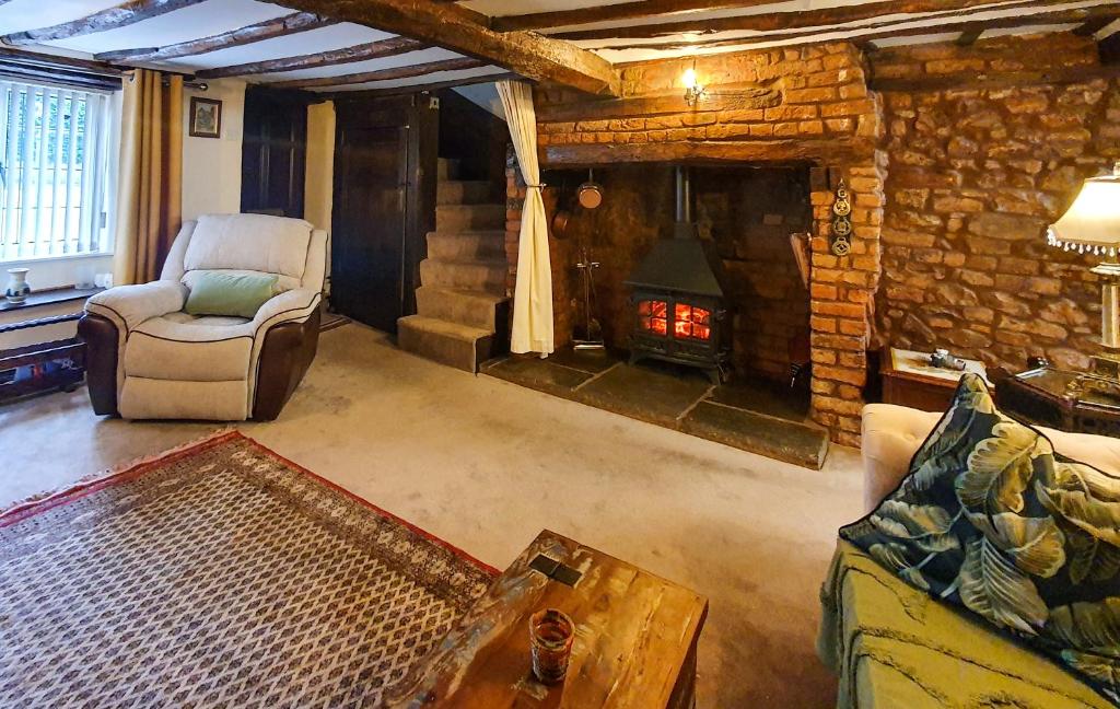uma sala de estar com um sofá e uma lareira em Magnolia Cottage em Wellington