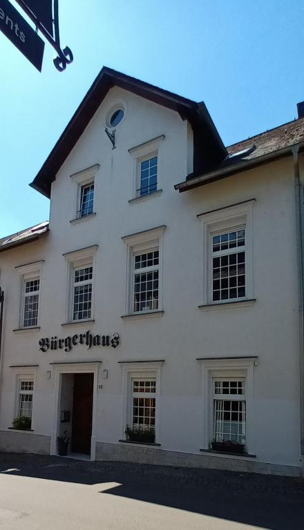 a white building with a sign on the side of it at Bürgerhaus Zeltingen Apartments Moselharmonie in Zeltingen-Rachtig