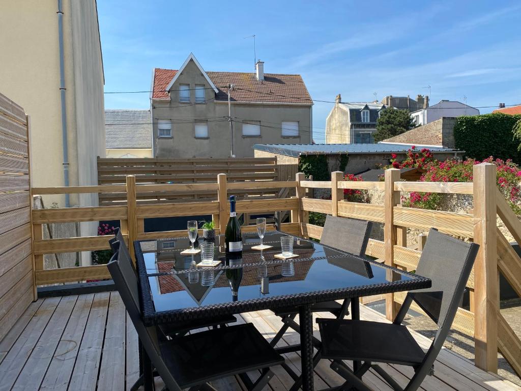 - une table avec des verres de vin sur le balcon dans l'établissement Nature - Gîte entièrement neuf à 100m de la plage, à Wimereux