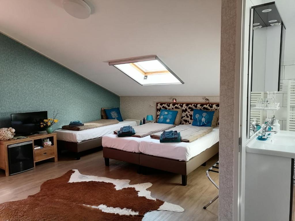 a bedroom with two beds and a sink and a mirror at Boerderij Hazenveld in Kockengen