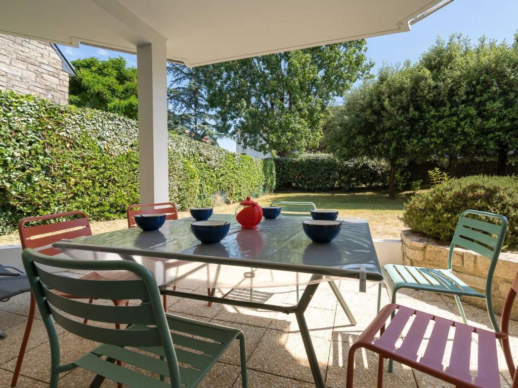 - une table de patio avec des bols et des chaises dans l'établissement Carnac : Appartement 3P, 6 pers, à 150m de la plage, Wifi, Parking, Animaux bienvenus - FR-1-477-1, à Carnac