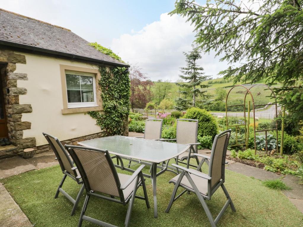 a table and chairs in the garden of a house at Swaledale Watch House Annexe in Wigton