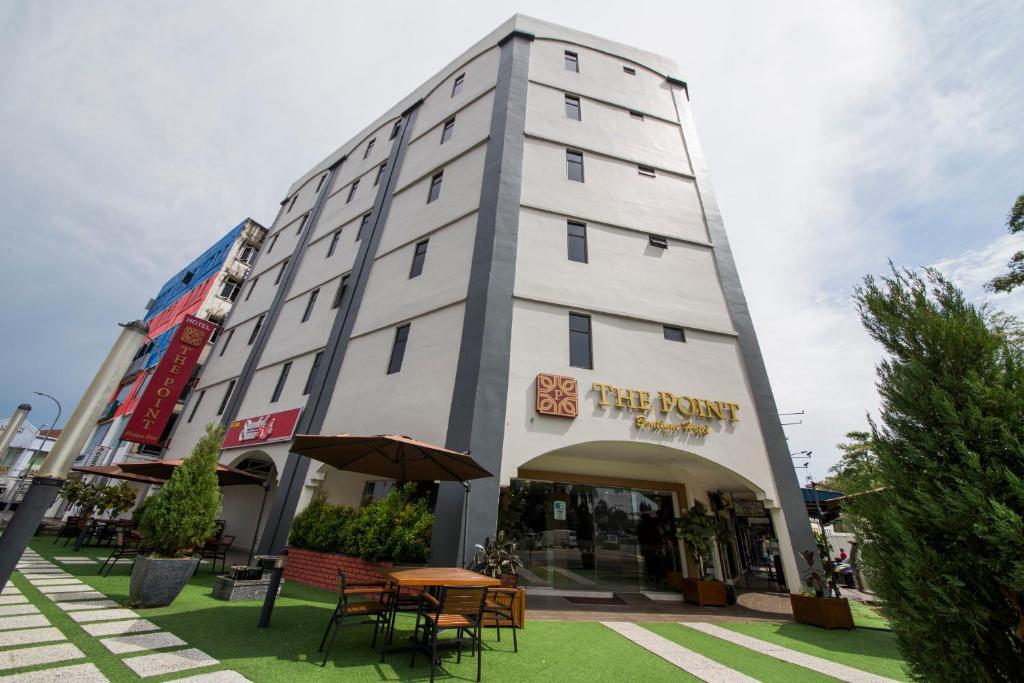 a large white building with tables and chairs in front of it at The Point Boutique Hotel in Johor Bahru