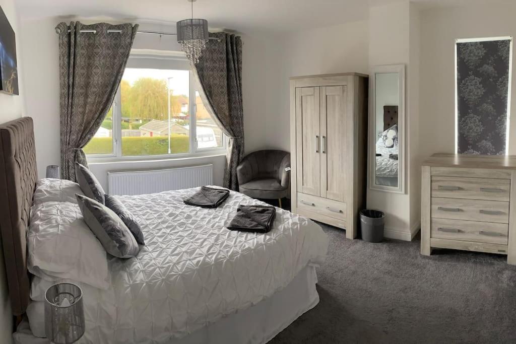 a bedroom with a bed and a window and a chair at Modern 4 bedroom house in Weymouth Sunny Corner in Weymouth