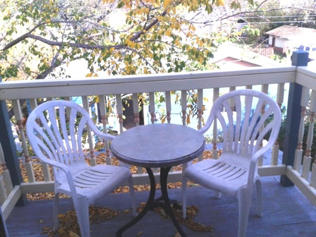 two chairs and a table on a porch at Phoenix House B&B in Stettler