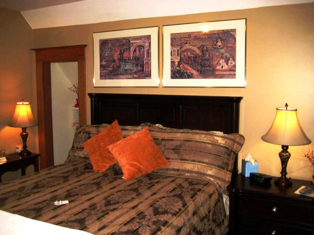 a bedroom with a bed and two pictures on the wall at Phoenix House B&B in Stettler