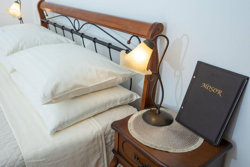une lampe sur une table de nuit à côté d'un lit dans l'établissement Apartments Mosor, à Omiš