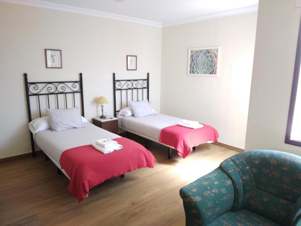 サン・クリストバル・デ・ラ・ラグーナにあるApartamento Esperantoのベッド2台とソファが備わるホテルルームです。