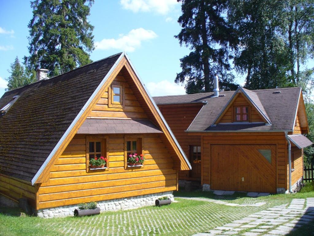 シュトーラにあるChalet Tatranecのガレージ付きの大きな木造家屋