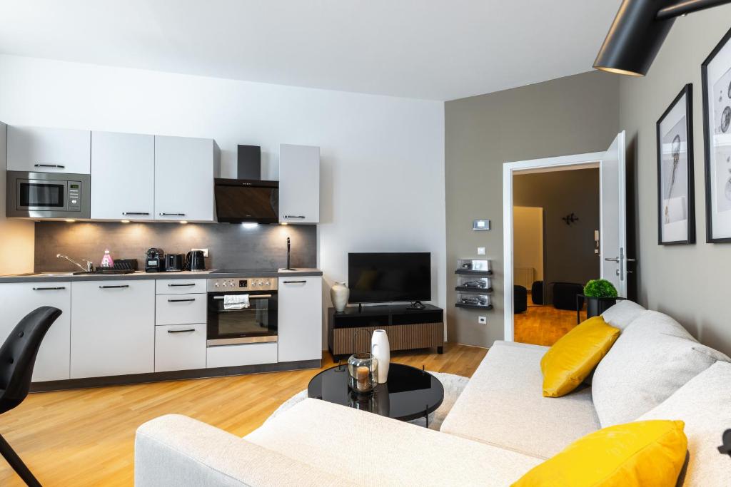 a living room with a couch and a kitchen at Trendy apt with - smart TV, coffee machine in Meidling in Vienna