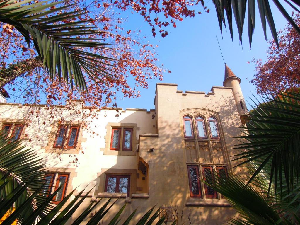 a building with a tower withwindows and a palm tree at Hostal Rio Amazonas in Santiago