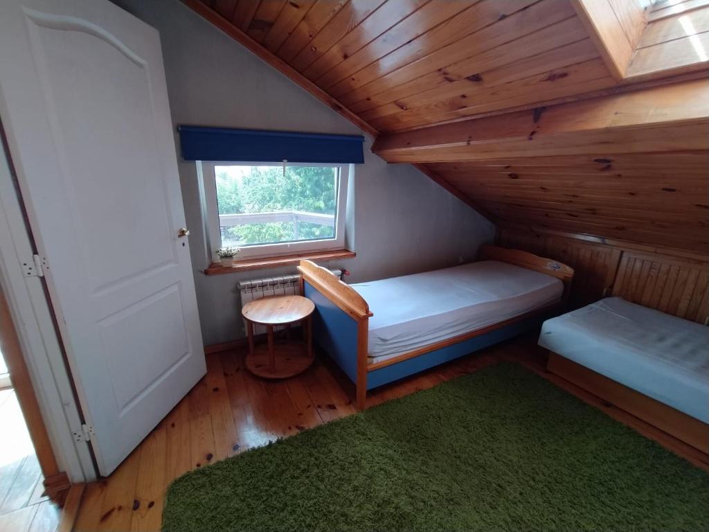 a small room with a bed and a window at Agroturystyka Pod Kogutem in Zamość