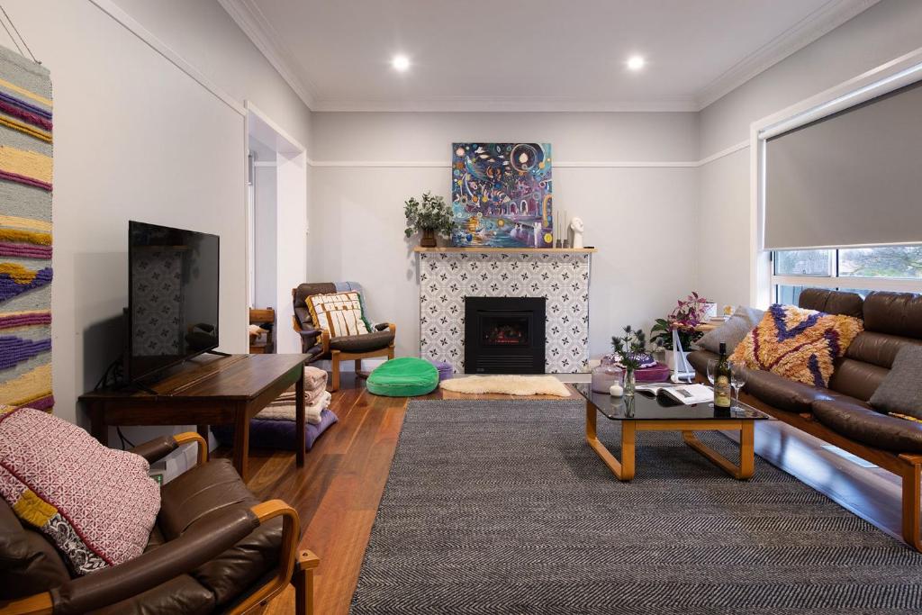 a living room with a couch and a fireplace at Little Olive in Kyneton