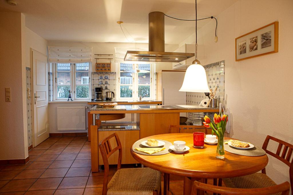 a kitchen with a wooden table and a dining room at Friesennest in Oldsum