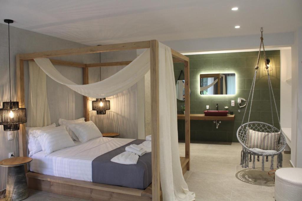 a bedroom with a canopy bed and a bathroom at elia boutique hotel in Parga