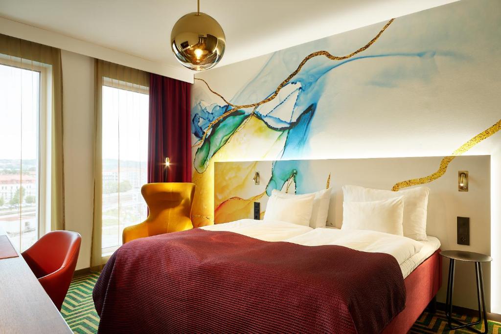 a bedroom with a bed with a painting on the wall at ProfilHotels Halmstad Plaza in Halmstad