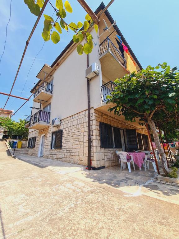 a building with a table and a tree in front of it at Apartments Viktorija in Pula