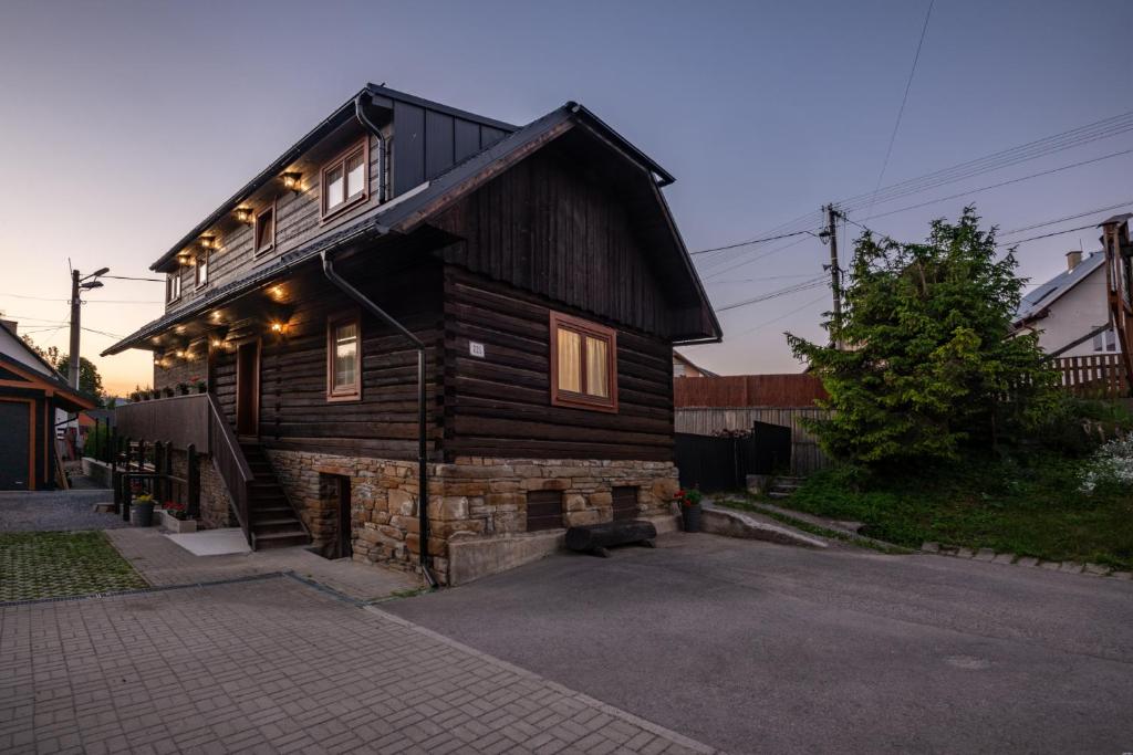 une maison en bois avec des lumières sur son côté dans l'établissement Drevenica Irenka, à Zuberec