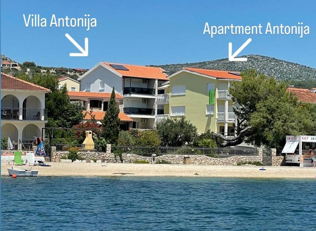 una vista desde el agua de una playa con edificios en Villa Antonia, en Rogoznica