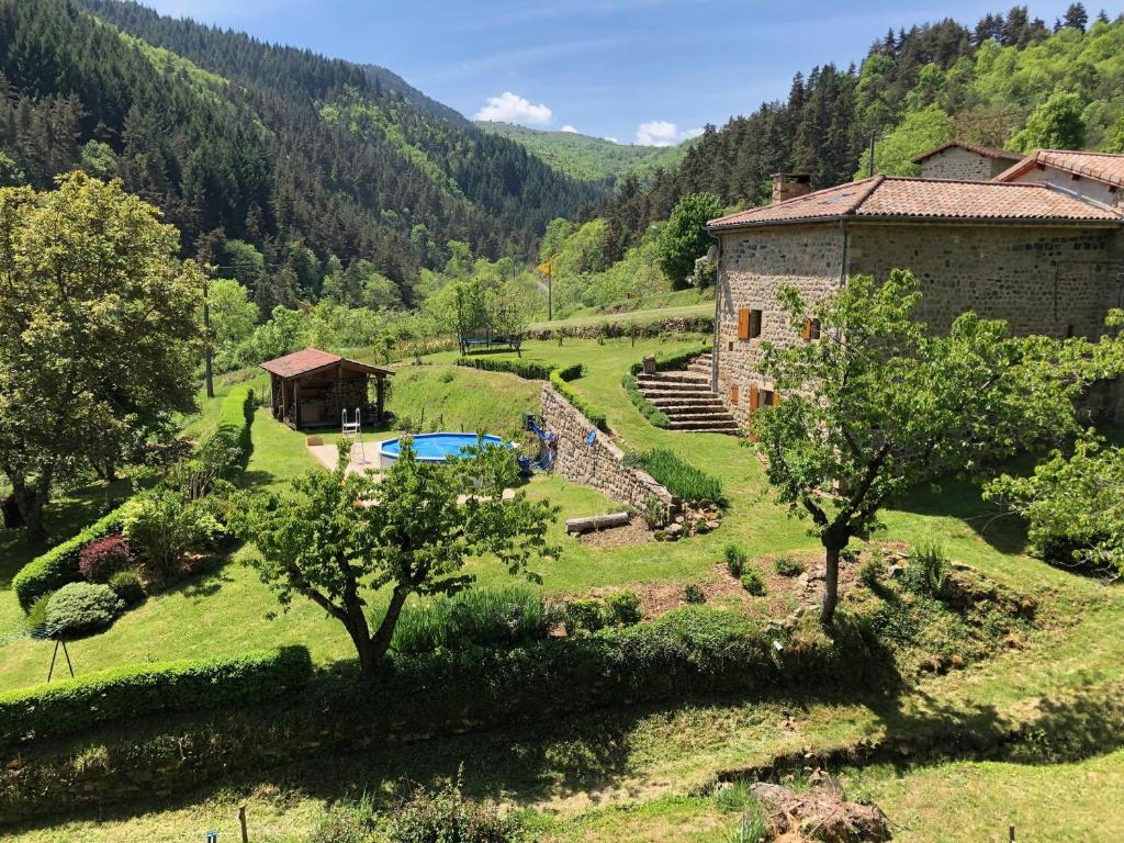 uma vista exterior de uma quinta e de uma piscina em Maison Coquelicot em Chanéac