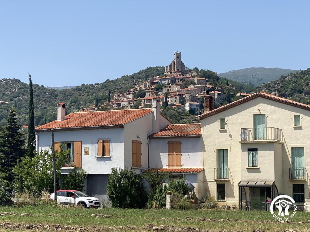 une maison blanche avec une colline en arrière-plan dans l'établissement Mas garrigole, à Eus