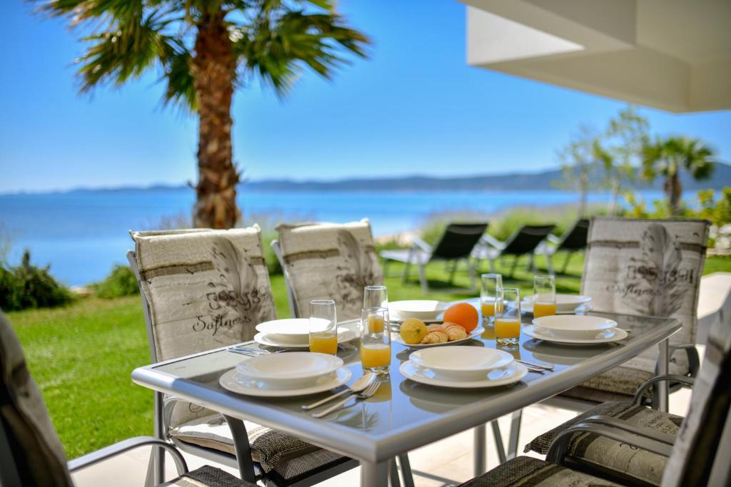 a table with plates of food and glasses of orange juice at "Babe" Beachfront Residence in Sukošan